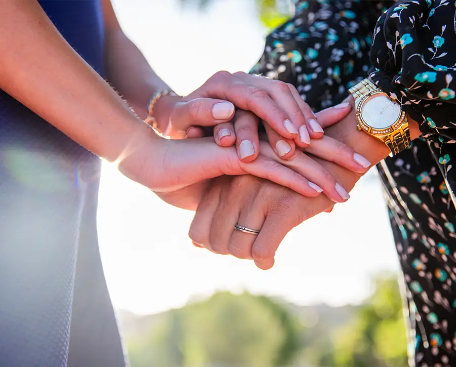 Hands placed one above the other as a sign of support and compassion during a funeral.